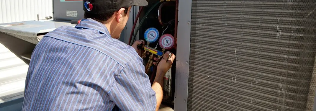 HVAC technician servicing a condenser unit in North Port